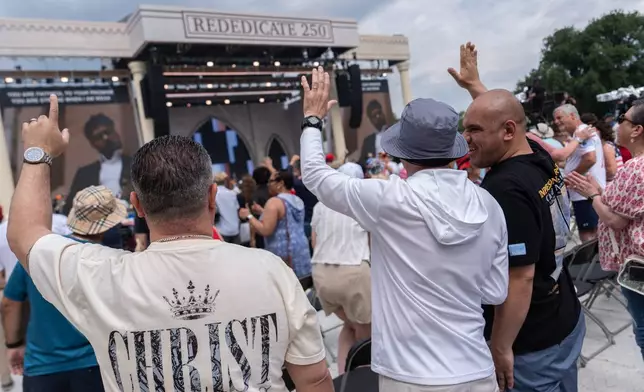 People worship to Christian music at Rededicate 250, a mostly conservative Christian prayer gathering in honor of the United States' 250th anniversary, on the National Mall, Sunday, May 17, 2026, in Washington. (AP Photo/Julia Demaree Nikhinson)