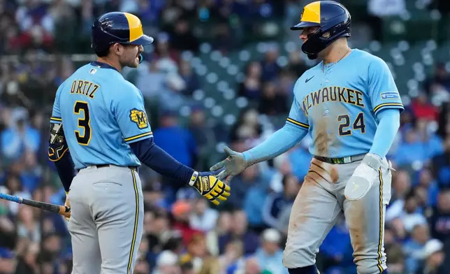 Milwaukee Brewers' William Contreras, right, celebrates with Joey Ortiz after scoring on a one-run single by Jake Bauers during the third inning of a baseball game against the Chicago Cubs in Chicago, Wednesday, May 20, 2026. (AP Photo/Nam Y. Huh)