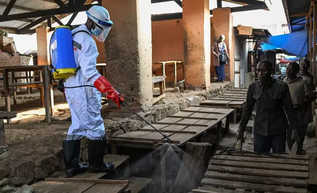 A sanitation worker from the Bunia city government sprays chlorine to disinfect the central market, as Ituri province continues to combat an Ebola outbreak, in Bunia, Congo, Saturday, May 23, 2026. (AP Photo/Moses Sawasawa)