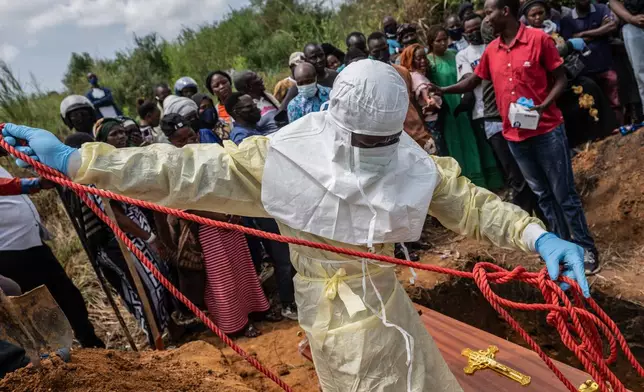 Red Cross workers prepare a coffin containing the body of a Ebola victim for burial at the Rwampara Cemetery, in Bunia, Congo, Saturday, May 23, 2026. (AP Photo/Moses Sawasawa)