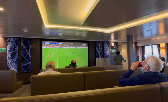 Passengers on the hantavirus-stricken cruise ship, MV Hondius, watch a football match on a television during their voyage to Spain's port of Tenerife, May 6, 2026. (AP Photo)