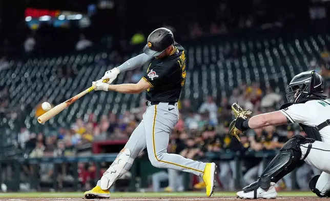 Pittsburgh Pirates' Brandon Lowe, left, connects for a home run as Arizona Diamondbacks catcher James McCann reaches for the ball during the first inning of a baseball game, Thursday, May 7, 2026, in Phoenix. (AP Photo/Ross D. Franklin)