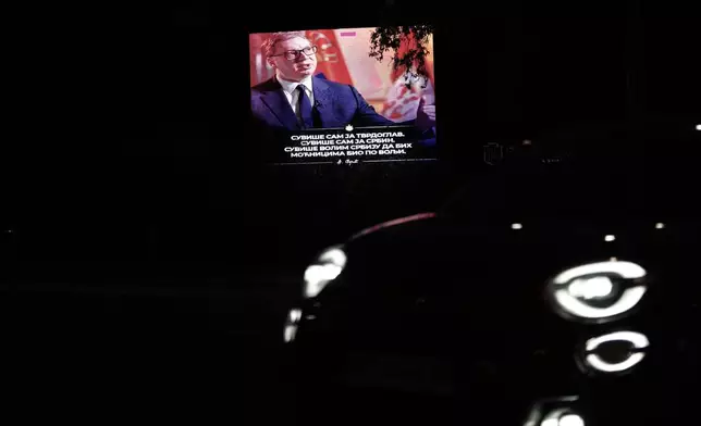 A car passes by a big screen showing Serbian President Aleksandar Vucic, reading: " I am too stubborn. I am too much of a Serb. I love Serbia too much to be to the taste of the power mongers." before his opponents first big rally this year in Belgrade, Serbia, Tuesday, May 19, 2026. (AP Photo/Darko Vojinovic)