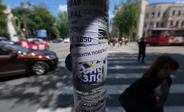 People walk by a lamppost with stickers that read: "Students win" before the first big rally this year of opponents of President Aleksandar Vucic in Belgrade, Serbia, Monday, May 18, 2026. (AP Photo/Darko Vojinovic)