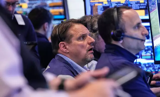 Trader Michael Milano, center, works with colleagues on the floor of the New York Stock Exchange, Wednesday, May 13, 2026. (AP Photo/Richard Drew)