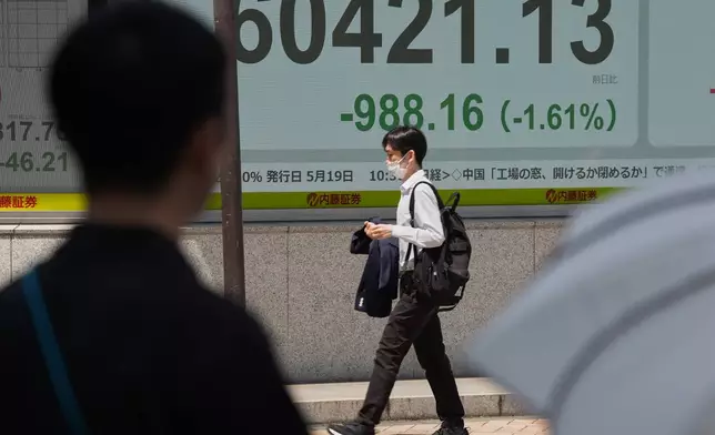 A person walks in front of an electronic stock board showing Japan's Nikkei index at a securities firm Monday, May 18, 2026, in Tokyo. (AP Photo/Eugene Hoshiko)