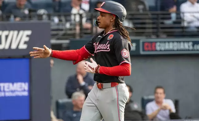Washington Nationals' CJ Abrams reaches for a teammate after hitting a solo home run off Cleveland Guardians starting pitcher Tanner Bibee during the third inning of a baseball game, Monday, May 25, 2026, in Cleveland. (AP Photo/Phil Long)