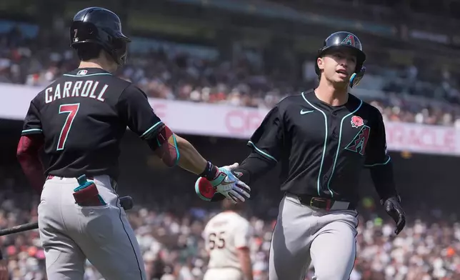 Arizona Diamondbacks' Tommy Troy, right, is congratulated by Corbin Carroll (7) after scoring against the San Francisco Giants during the fifth inning of a baseball game Monday, May 25, 2026, in San Francisco. (AP Photo/Jeff Chiu)