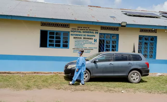 A health worker wearing protective gear walks outside the a hospital in Bunia, Congo, Saturday, May 16, 2026. (AP Photo/Jorkim Jotham Pituwa)