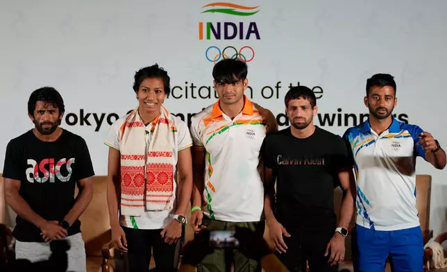 FILE - From left, Olympic Bronze medallist in wrestling Bajarng Punia, Olympic Bronze medallists in boxing, Lovlina Borgohain, Olympic Gold medallist in javelin throw Neeraj Chopra, Olympic Silver medallist in wrestling Ravi Dahiya and captain of Indian men's hockey team who won bronze medal, Manpreet Singh at Tokyo Olympic games, stand for a photographs during a felicitation function in New Delhi, India, Monday, Aug. 9 2021. (AP Photo/Manish Swarup.File)