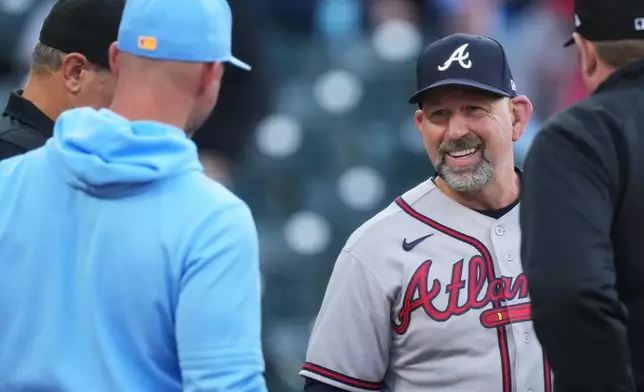 Colorado Rockies manager Warren Schaeffer, front left, greets Atlanta Braves manager Walt Weiss, back right, as they exchange lineup cards at home plate before a baseball game Friday, May 1, 2026, in Denver. (AP Photo/David Zalubowski)