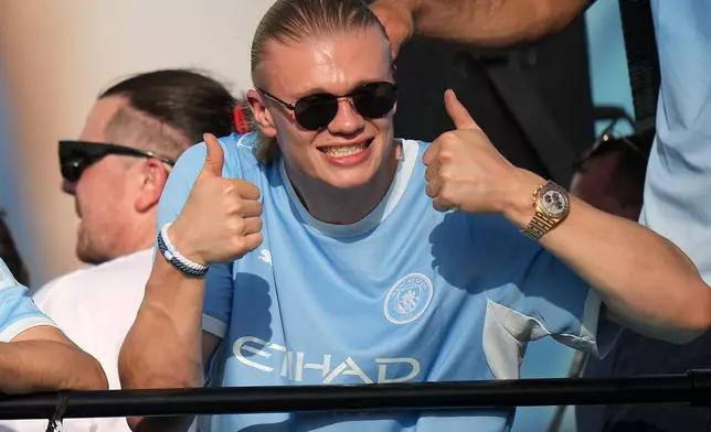 Manchester City's Erling Haaland celebrates on an open top bus during a parade to celebrate the achievements of the Manchester City men's and women's teams this season in Manchester, Monday, May 25, 2026.(AP Photo/Alastair Grant)