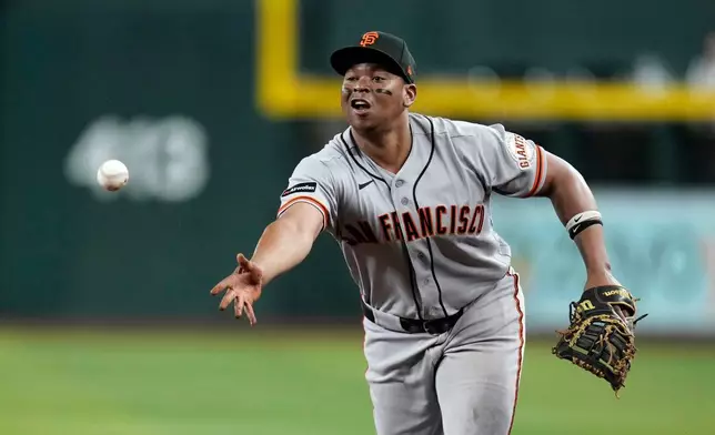 San Francisco Giants first baseman Rafael Devers tosses to first base to get Arizona Diamondbacks' Jorge Barrosa out during the fourth inning of a baseball game, Wednesday, May 20, 2026, in Phoenix. (AP Photo/Ross D. Franklin)