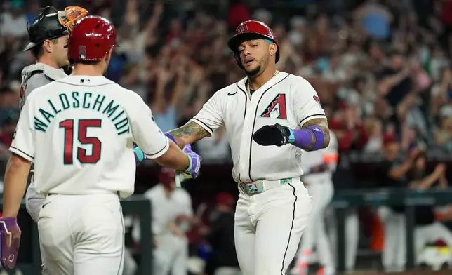 Arizona Diamondbacks' Ryan Waldschmidt (15) and Ketel Marte celebrate their runs scored against the San Francisco Giants during the fifth inning of a baseball game, Wednesday, May 20, 2026, in Phoenix. (AP Photo/Ross D. Franklin)