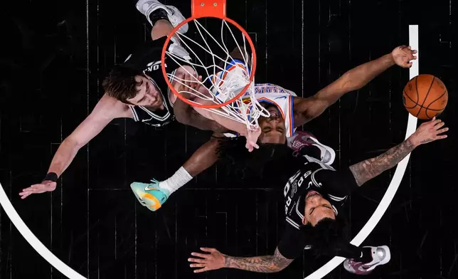 Oklahoma City Thunder guard Cason Wallace (22) shoots against San Antonio Spurs forward Julian Champagnie (30) in the second half of Game 6 in the Western Conference finals NBA basketball playoffs series, Thursday, May 28, 2026, in San Antonio. (AP Photo/David J. Phillip)