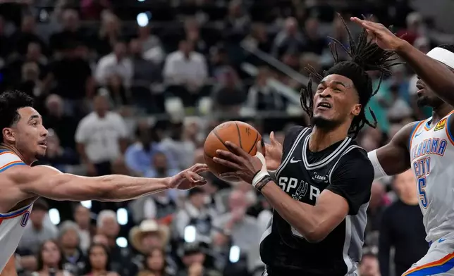 San Antonio Spurs guard Stephon Castle (5) drives past Oklahoma City Thunder guard Luguentz Dort (5) in the second half of Game 6 in the Western Conference finals NBA basketball playoffs series, Thursday, May 28, 2026, in San Antonio. (AP Photo/David J. Phillip)