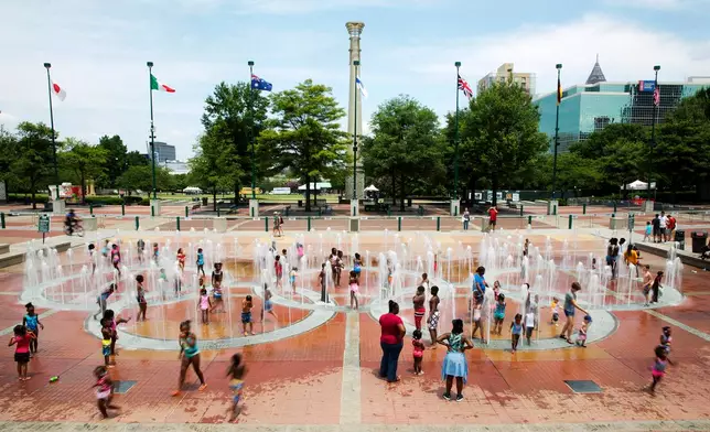 FILE - People play in the fountains shaped by the Olympic rings at Centennial Olympic Park in Atlanta, July 22, 2016. (AP Photo/David Goldman, File)