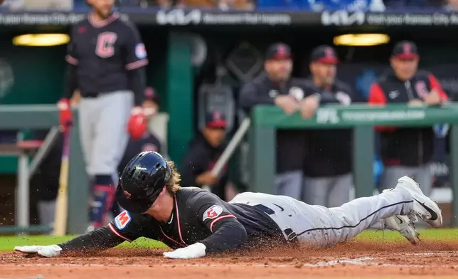 Cleveland Guardians' Petey Halpin slides home to score on a two-run single hit by Chase DeLauter during the fifth inning of a baseball game against the Kansas City Royals, Wednesday, May 6, 2026, in Kansas City, Mo. (AP Photo/Charlie Riedel)