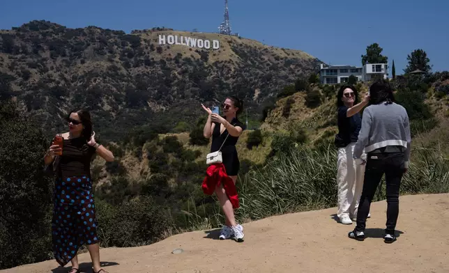 Tourists take selfies with the Hollywood sign in the background in Los Angeles, May 8, 2026. (AP Photo/Jae C. Hong)