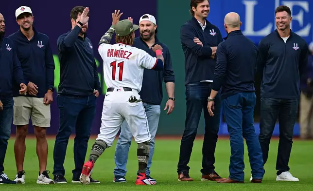 Cleveland Guardians third baseman Jose Ramirez (11) gives former Cleveland Indians player Jason Kipnis, center right, a high-five during a reunion of the 2016 Indians before a baseball game against between the Guardians and the Cincinnati Reds, Friday, May 15, 2026, in Cleveland. (AP Photo/David Dermer)