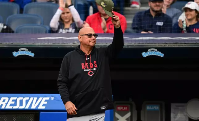 Cincinnati Reds manager Terry Francona waives his cap to the fans during a reunion of the 2016 Cleveland Indians before a baseball game between the Cleveland Guardians and the Reds, Friday, May 15, 2026, in Cleveland. (AP Photo/David Dermer)