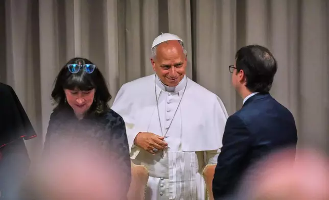 Pope Leo XIV, talks to Anthropic co-founder Christopher Olah, right, and theologian Anna Rowlands, left, during the presentation of his first encyclical, "Magnifica humanitas: On Safeguarding the Human Person in the Time of Artificial Intelligence," at the Vatican, Monday, May 25, 2026. (AP Photo/Alessandra Tarantino)