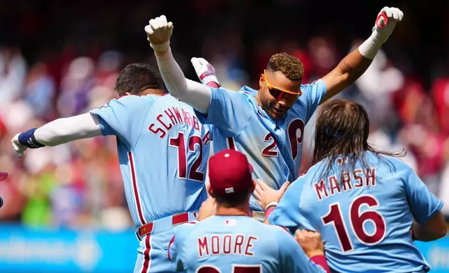 Philadelphia Phillies' Justin Crawford (2) celebrates his walk-off RBI single with Kyle Schwarber (12) after the first baseball game of a doubleheader against the San Francisco Giants, Thursday, April 30, 2026, in Philadelphia. (AP Photo/Derik Hamilton)