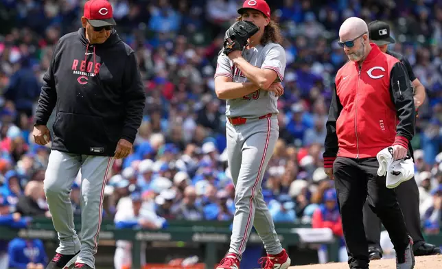 Cincinnati Reds starting pitcher Rhett Lowder, center, leaves with manager Terry Francona, left, and a team trainer after an injury during the fourth inning of a baseball game against the Chicago Cubs in Chicago, Thursday, May 7, 2026. (AP Photo/Nam Y. Huh)