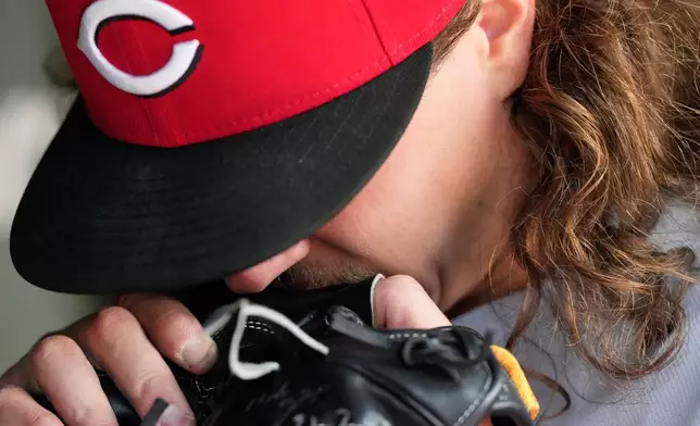 Cincinnati Reds starting pitcher Rhett Lowder bites his glove in the dugout after an injury during the fourth inning of a baseball game against the Chicago Cubs in Chicago, Thursday, May 7, 2026. (AP Photo/Nam Y. Huh)