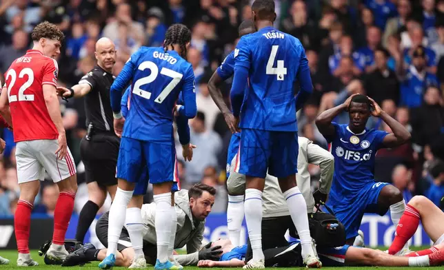 Chelsea's Jesse Derry is treated by medical staff after a clash of heads with Nottingham Forest's Zach Abbott during the English Premier League soccer match between Chelsea and Nottingham Forest in London, Monday, May 4, 2026. (John Walton/PA via AP)