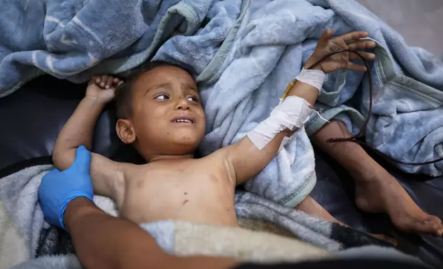 A child wounded in an explosion caused by war remnants while playing with other children in the village of Abu Habbah in eastern Idlib countryside, is treated at the hospital in Maaret al-Numan, Syria, Thursday, May 21, 2026. Three other children were also wounded and three others killed.(AP Photo/Ghaith Alsayed)