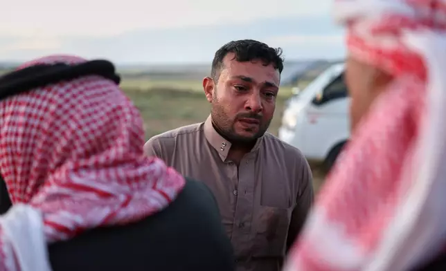 Idris Al-Ridah, center, receives condolences from friends and neighbors during the funeral of his son Amir, who was killed in an explosion caused by war remnants while playing with other children in the village of Abu Habbah in eastern Idlib countryside, in Abu Habbah, Syria, Thursday, May 21, 2026. Two other children were also killed and four others wounded. (AP Photo/Ghaith Alsayed)