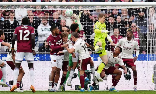 Arsenal goalkeeper David Raya, center, is fouled by West Ham United's Pablo Felipe in the build up to Callum Wilson disallowed goal during the English Premier League match in London, Sunday May 10, 2026. (John Walton/PA via AP)