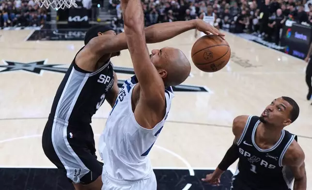 Minnesota Timberwolves center Rudy Gobert, center, is blocked by San Antonio Spurs forward Keldon Johnson (3) as forward Victor Wembanyama (1) looks on during the second half of Game 5 of an NBA basketball second-round playoffs series in Minneapolis, Tuesday, May 12, 2026. (AP Photo/Eric Gay)
