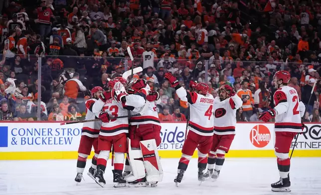 Carolina Hurricanes' players celebrate after winning Game 4 against the Philadelphia Flyers in a second-round NHL hockey Stanley Cup playoff series Saturday, May 9, 2026, in Philadelphia. (AP Photo/Matt Slocum)