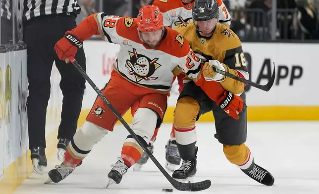 Anaheim Ducks left wing Jeffrey Viel (28) and Vegas Golden Knights right wing Pavel Dorofeyev (16) vie for the puck during the first period of Game 1 of a second-round NHL hockey Stanley Cup playoff series Monday, May 4, 2026, in Las Vegas. (AP Photo/John Locher)