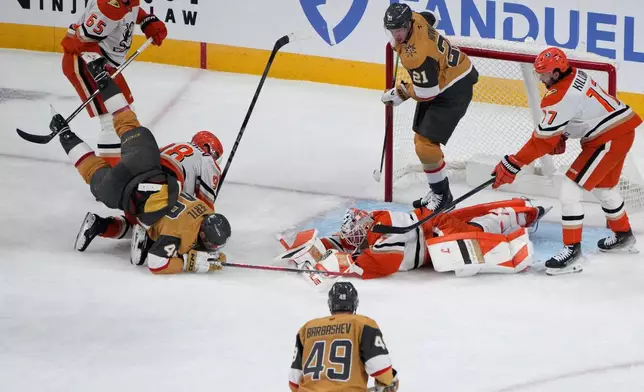 Anaheim Ducks goaltender Lukas Dostal (1) covers the puck against the Vegas Golden Knights during the first period of Game 1 of a second-round NHL hockey Stanley Cup playoff series Monday, May 4, 2026, in Las Vegas. (AP Photo/John Locher)
