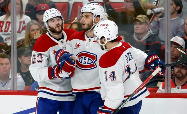 Montréal Canadiens' Juraj Slafkovský (20), center, celebrates his goal with Nick Suzuki (14) and Noah Dobson (53) during the third period in Game 1 of the Eastern Conference finals NHL hockey Stanley Cup playoffs series against the Carolina Hurricanes in Raleigh, N.C., Thursday, May 21, 2026. (AP Photo/Karl DeBlaker)