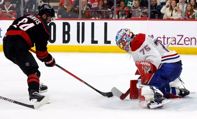 Carolina Hurricanes' Seth Jarvis (24) has his shot blocked by Montréal Canadiens goaltender Jakub Dobes (75) during the second period in Game 1 of the Eastern Conference finals NHL hockey Stanley Cup playoffs series in Raleigh, N.C., Thursday, May 21, 2026. (AP Photo/Karl DeBlaker)