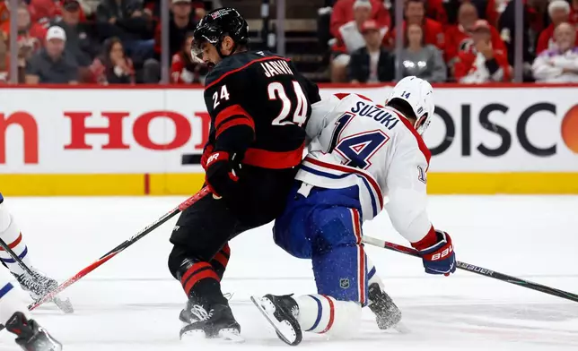 Carolina Hurricanes' Seth Jarvis (24) collides with Montréal Canadiens' Nick Suzuki (14) during the first period in Game 1 of the Eastern Conference finals NHL hockey Stanley Cup playoffs series in Raleigh, N.C., Thursday, May 21, 2026. (AP Photo/Karl DeBlaker)