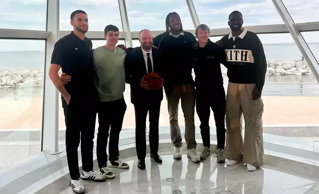 Milwaukee Bucks' new head coach Taylor Jenkins, third from left, poses with Bucks players, from left, Pete Nance, Cormac Ryan, Myles Turner, AJ Green and Bobby Portis after an NBA basketball news conference, Wednesday, May 6, 2026, at the Milwaukee Art Museum in Milwaukee. (AP Photo/Steve Megargee)
