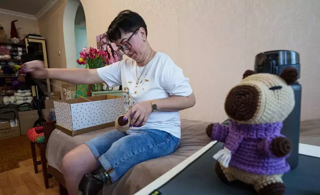 Iryna Nakonechna knits a toy capybara at her home in Kryvyi Rih, Ukraine, Saturday, May 9, 2026. (AP Photo/Evgeniy Maloletka)