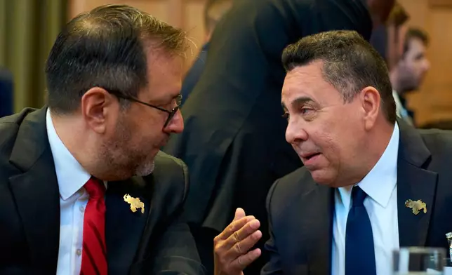 Samuel Reinaldo Moncada Acosta, right, speaks to Venezuela's Foreign Affairs minister Yvan Gil Pinto as the International Court of Justice opens a week of hearings in a border dispute dating back to the end of the 19th century between Guyana and Venezuela, in The Hague, Netherlands, Monday, May 4, 2026. (AP Photo/Peter Dejong)