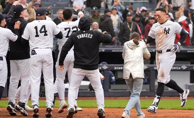 New York Yankees' Aaron Judge, right, reacts as he comes home after hitting a two-run walk-off home run during the ninth inning of a baseball game against the Tampa Bay Rays, Sunday, May 24, 2026, in New York. (AP Photo/Seth Wenig)