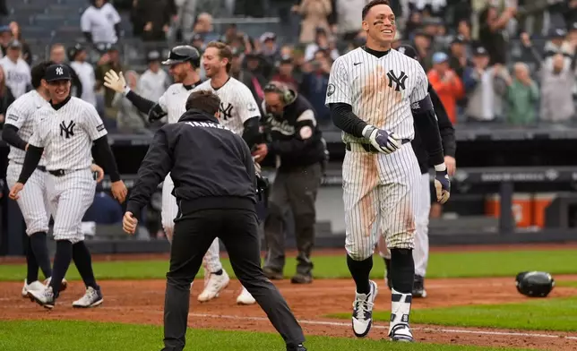 New York Yankees' Aaron Judge, right, reacts after hitting a two-run walk-off home run during the ninth inning of a baseball game against the Tampa Bay Rays, Sunday, May 24, 2026, in New York. (AP Photo/Seth Wenig)