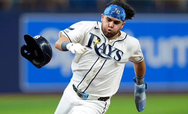 Tampa Bay Rays' Jonathan Aranda loses his helmet as he scores on an RBI double by Yandy Díaz off Baltimore Orioles pitcher Kyle Bradish during the first inning of a baseball game Tuesday, May 19, 2026, in St. Petersburg, Fla. (AP Photo/Chris O'Meara)