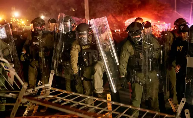 Police pass over a barricade as they clash with protesters near the Delaney Hall detention center during a protest against the transfer of detainees and federal immigration policies on Saturday, May 30, 2026, in Newark, N.J. (AP Photo/Andres Kudacki)