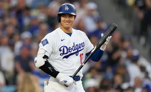 Los Angeles Dodgers' Shohei Ohtani smiles toward the San Francisco Giants' dugout as he walks up to bat during the first inning of a baseball game Tuesday, May 12, 2026, in Los Angeles. (AP Photo/Mark J. Terrill)