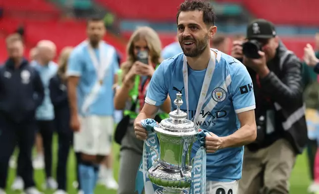 Manchester City's Bernardo Silva holds the winner's trophy after the English FA Cup final soccer match between Chelsea and Manchester City in London, Saturday, May 16, 2026. (AP Photo/Richard Pelham)