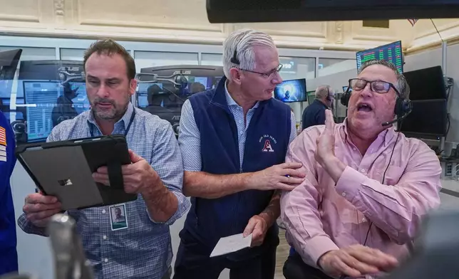 Options trader, left to right, Scott Frinzi, Dave Rushand and Marty Handler, work on the floor of the New York Stock Exchange, Friday, May 1, 2026. (AP Photo/Richard Drew)